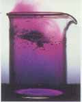 Image of purple gas coming off of a beaker filled with purple liquid.