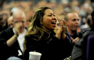 A smiling woman in the middle of a crowd.