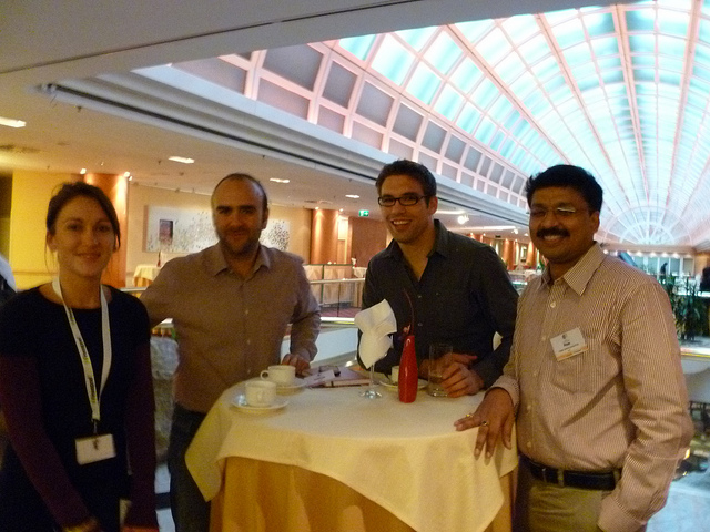 Four people networking at a busy event