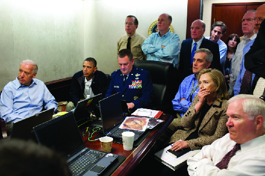 An image of Barack Obama, Joe Biden, Hillary Clinton, Robert Gates, and other national security advisors in the White House S