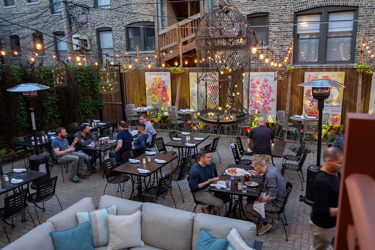 Several people sit at tables at an outdoor restauran