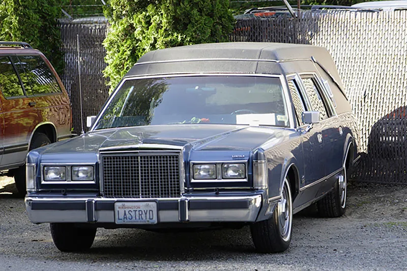 A hearse with the license plate "LASTRYD" is shown here.