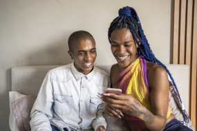 Group of individuals looking at phone smiling