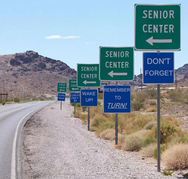 Five sets of road signs, the top one green and the bottom one red in each set, are shown along the right-hand side of a road 