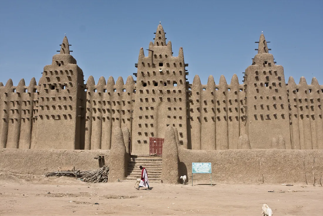 A photograph shows a large, brown structure with many points along the top. Three portions are shown jutting out. Stairs in t