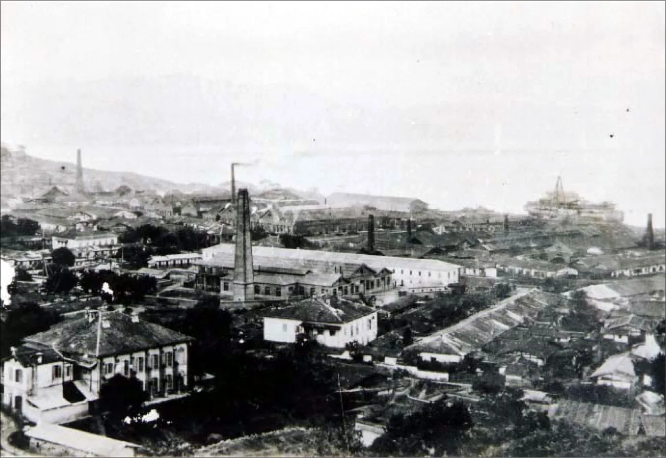 A photograph shows a tall tower in the middle surrounded by short buildings of various sizes and positioned in various direct