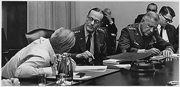 President Johnson (turned away from the camera) in conversation with Chairman of the Joint Chiefs of Staff Earle Wheeler (l) 