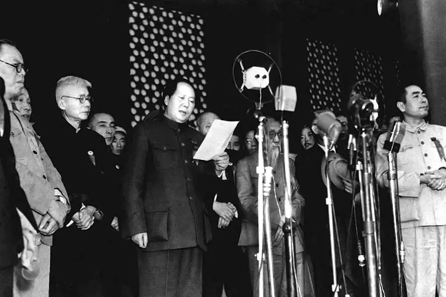 A photograph shows men standing behind several standing microphones. The men are of Asian descent, wearing suits. Some have g